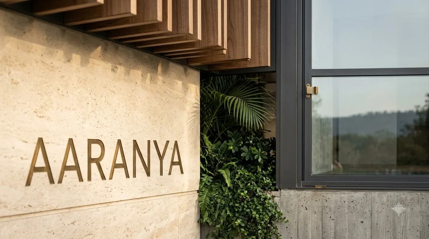 AARANYA lettering on travertine, vertical teak slats & foliage
